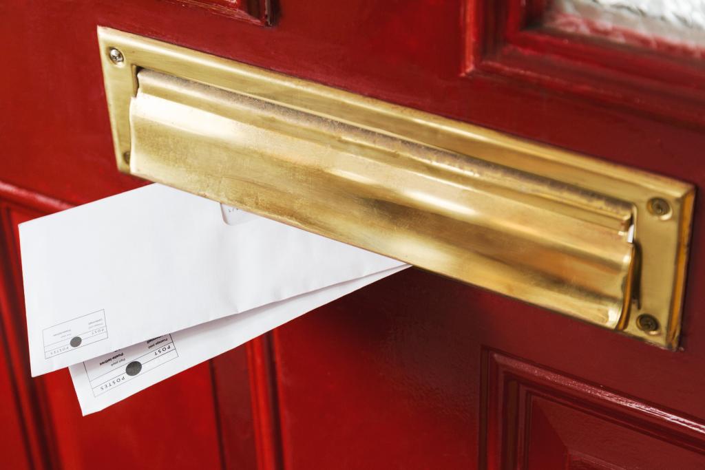 mail peeks out from a brass letterbox 1024x683 1