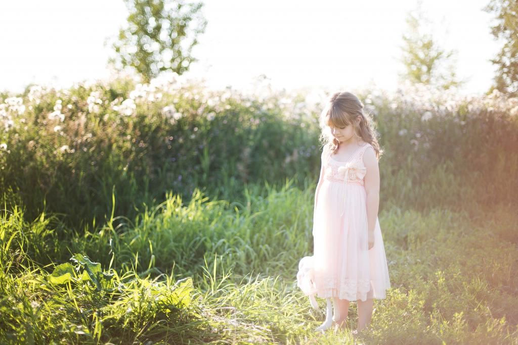 girl in pink looking down at grass 1024x683 1